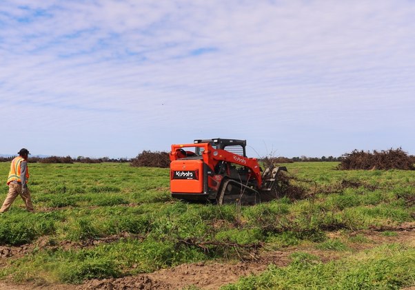 Tractor and implement working an open field